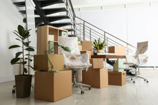 Movers packing desks and equipment during an office relocation